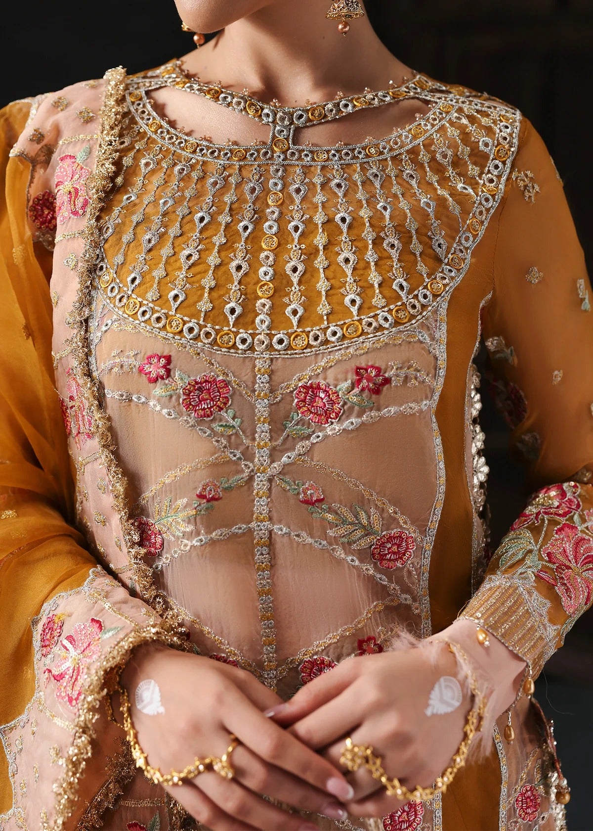 Chic mustard organza suit with applique front, embroidered neckline, dupatta with 4-side border, and raw silk trouser — perfect for festive wear.