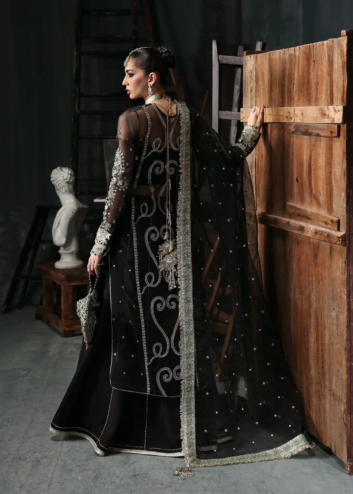 Elegant black organza dress with embroidered cutwork panels, dupatta & raw silk trouser. Available stitched or unstitched with custom sizing options.