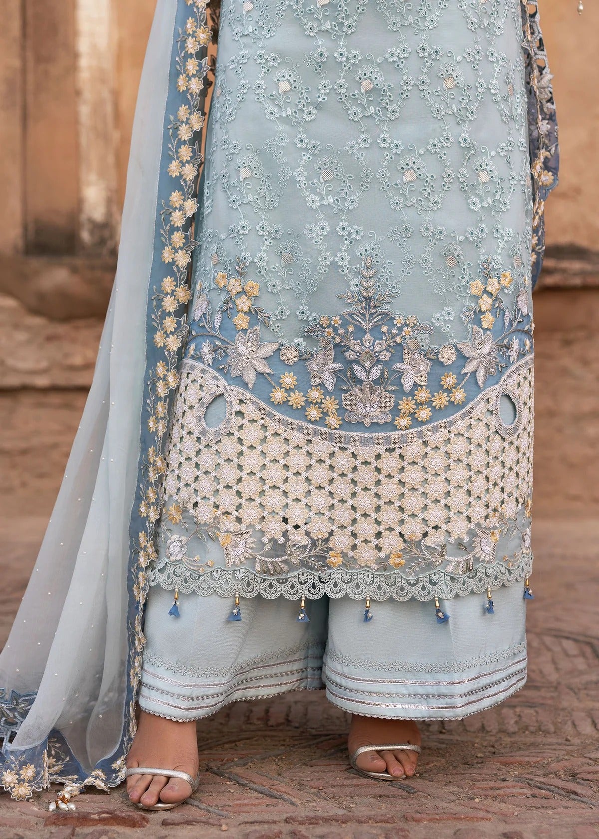 Luxury chiffon suit with hand-embellished neckline, 3D floral sleeve motifs, cutwork borders, diamante dupatta, and raw silk trouser — perfect for occasions.