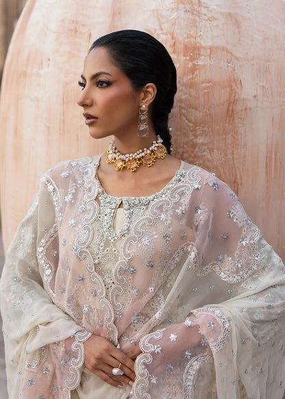 Elegant chiffon embroidered suit with hand embellishment, cutwork borders, diamante & mukesh dupatta, and raw silk trouser perfect for festive wear.