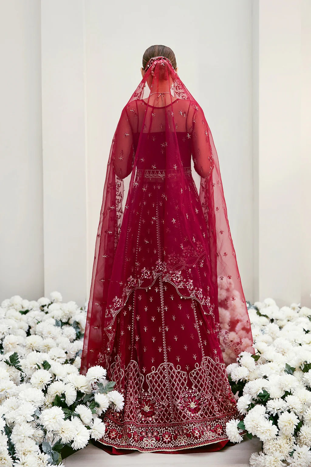 Graceful organza and poly net embroidered suit featuring hand-embellished bodice, cutwork panels, organza borders, dupatta, and raw silk trouser fabric.