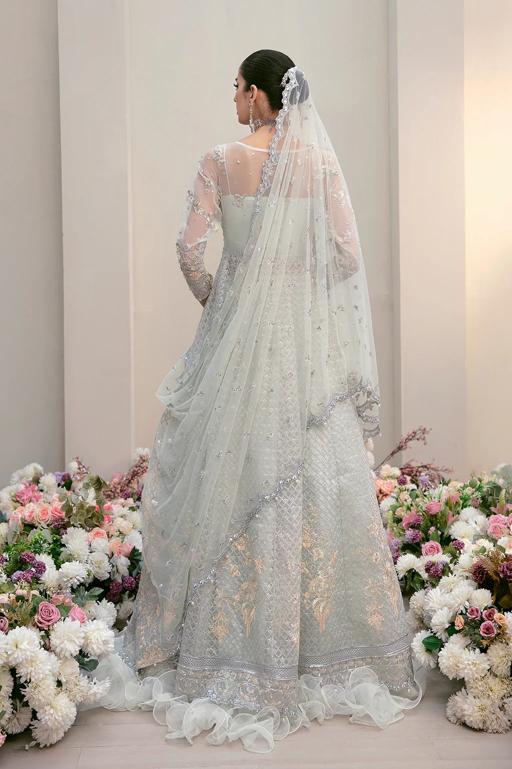 Elegant organza embroidered suit with hand-embellished bodice, cutwork panels, detailed borders, dupatta, and premium raw silk trouser fabric.