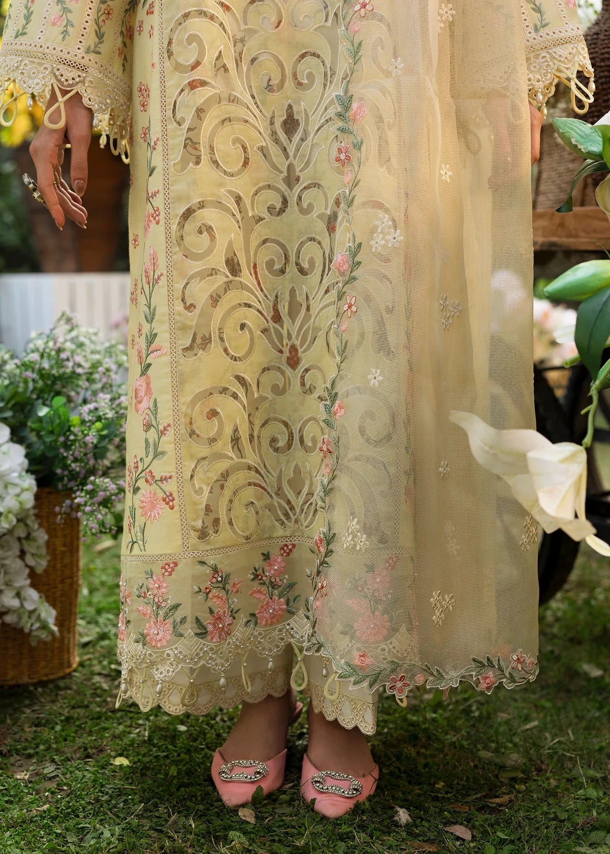 Shop this yellow embroidered lawn suit with chikan-kari sleeves, organza borders, woven net dupatta, and cotton trouser for an elegant summer look.