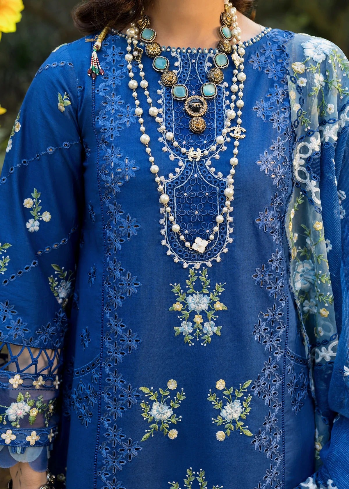 Step into elegance with this blue embroidered lawn suit featuring chikan-kari panels, hand-work neckline, net dupatta, and cotton trouser.