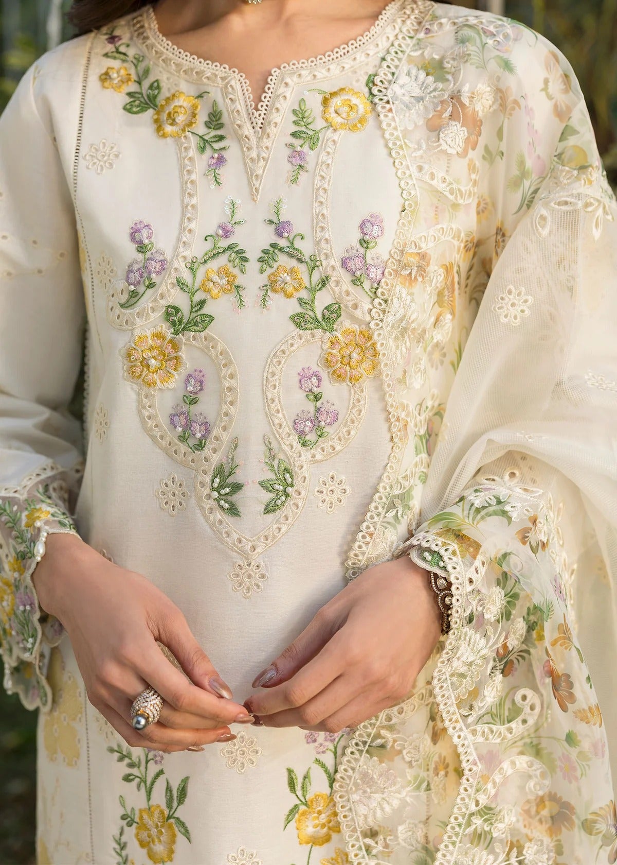 Look elegant in this ivory embroidered lawn suit with chikan-kari panels, hand-work neckline, woven net dupatta, and cotton trouser for a timeless style.