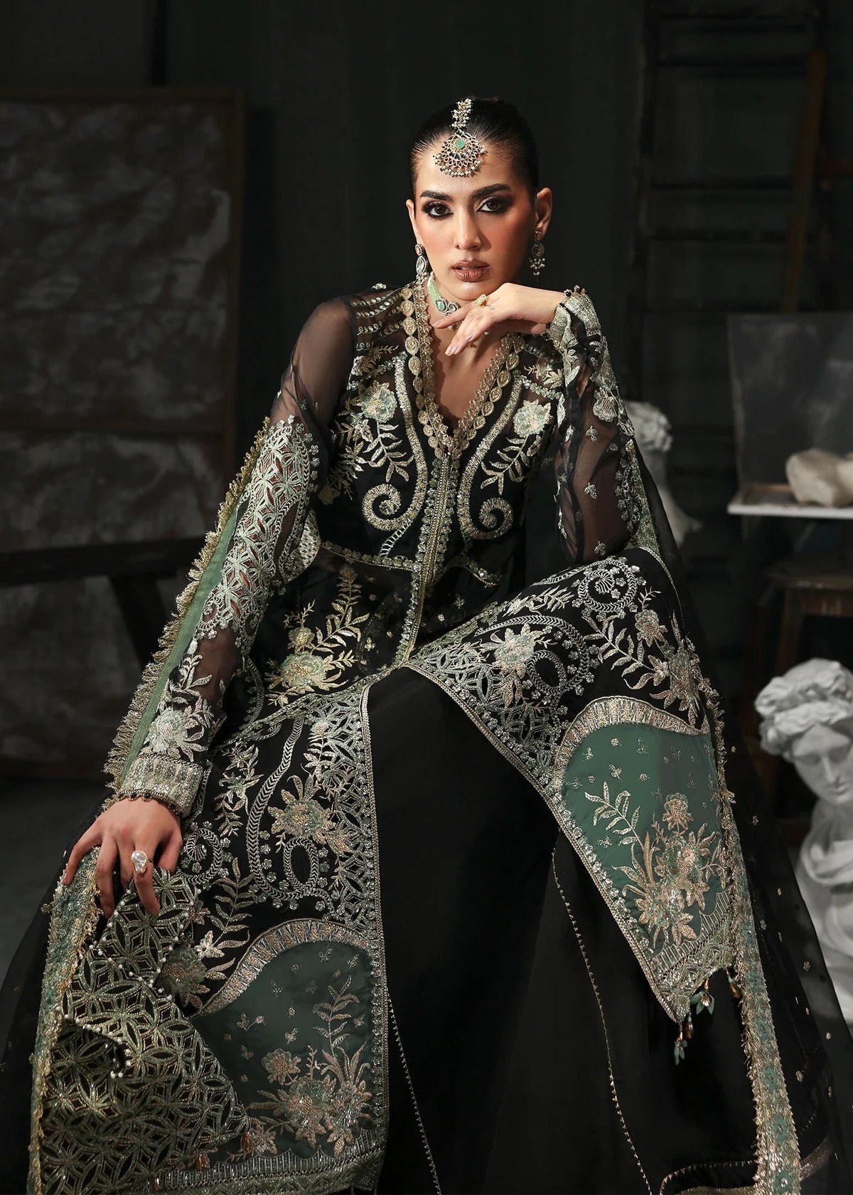 Elegant black organza dress with embroidered cutwork panels, dupatta & raw silk trouser. Available stitched or unstitched with custom sizing options.