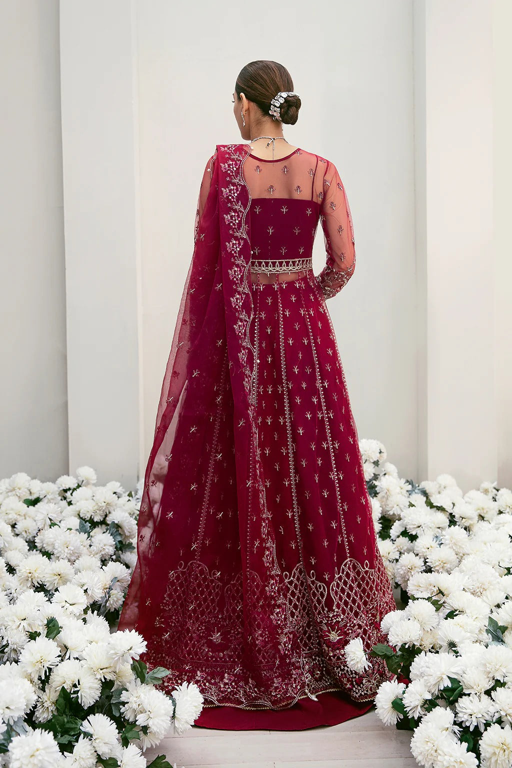Graceful organza and poly net embroidered suit featuring hand-embellished bodice, cutwork panels, organza borders, dupatta, and raw silk trouser fabric.