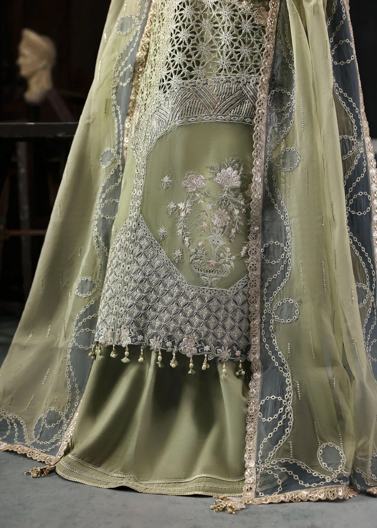 Graceful olive green organza suit with dori work, cutwork neckline, embroidered dupatta, and raw silk trouser a perfect choice for festive elegance.