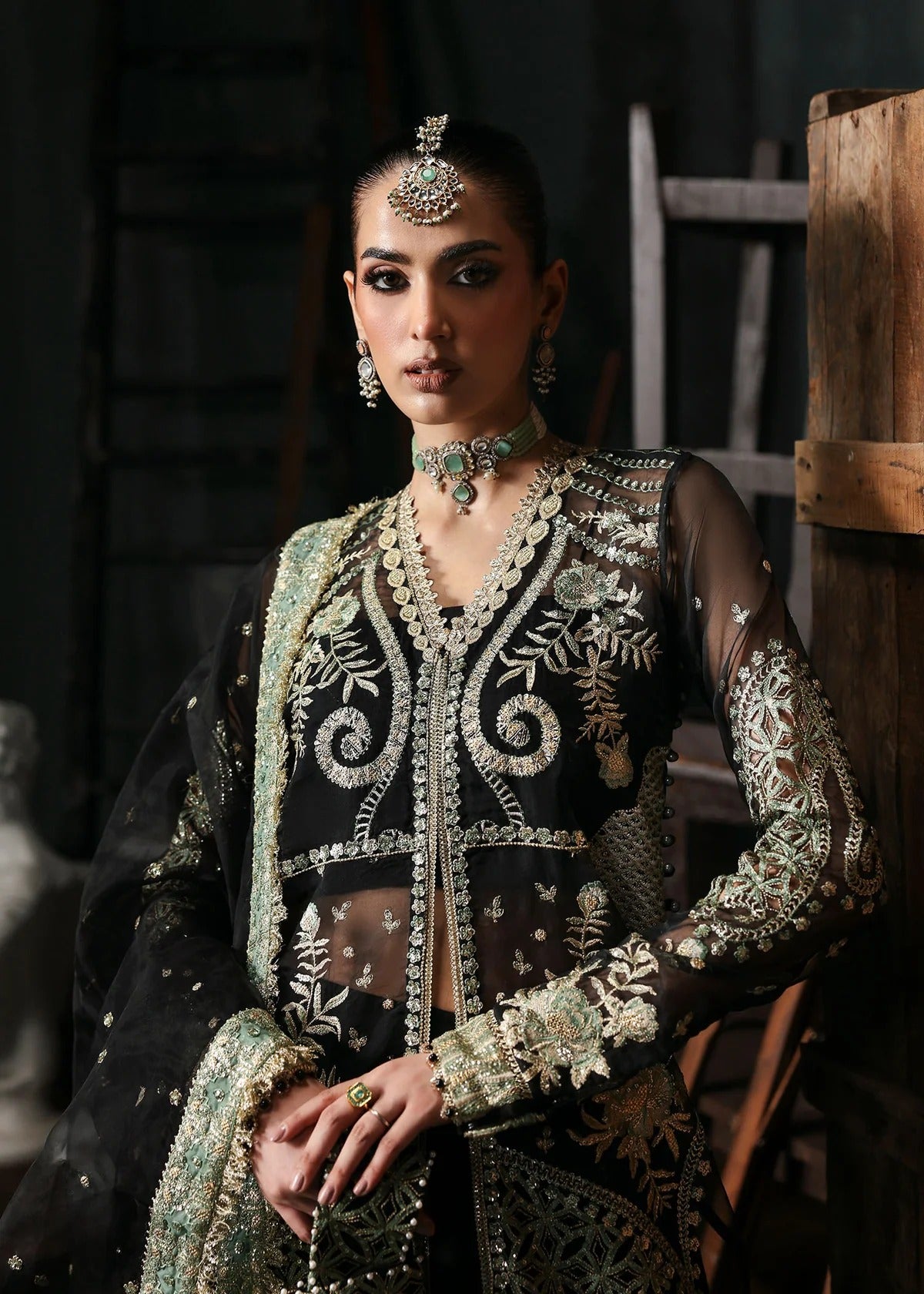 Elegant black organza dress with embroidered cutwork panels, dupatta & raw silk trouser. Available stitched or unstitched with custom sizing options.