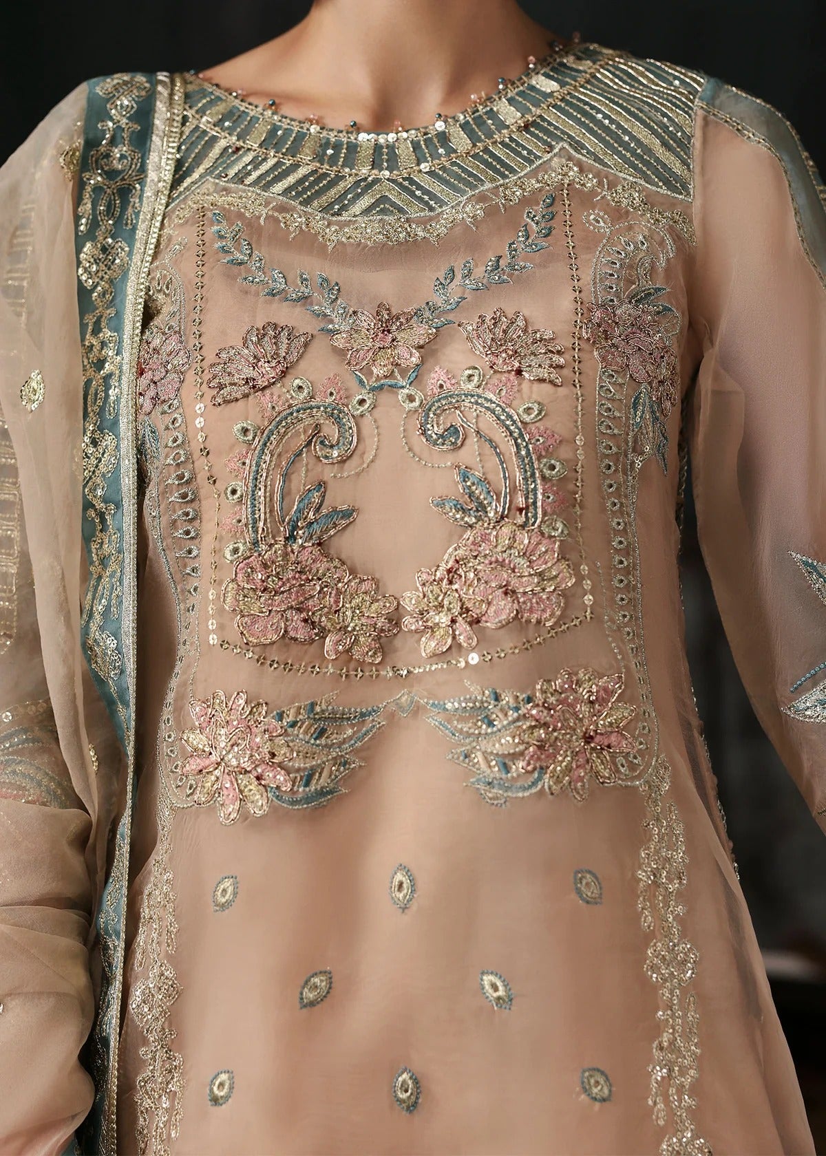 Elegant pale pink organza suit with dori work panels, applique neckline, embroidered dupatta, and raw silk trouser — perfect for festive occasions.
