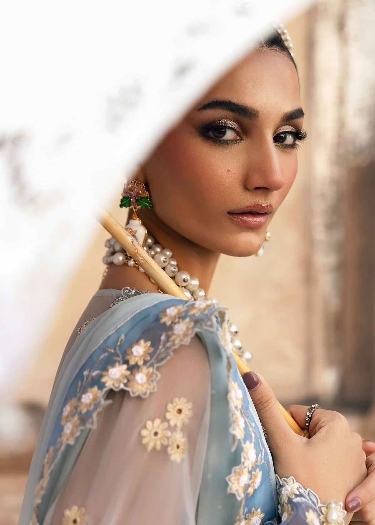 Luxury chiffon suit with hand-embellished neckline, 3D floral sleeve motifs, cutwork borders, diamante dupatta, and raw silk trouser — perfect for occasions.
