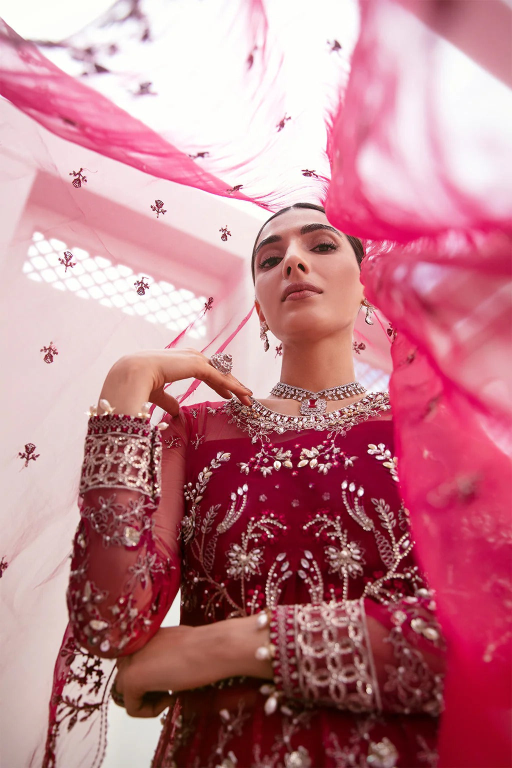 Graceful organza and poly net embroidered suit featuring hand-embellished bodice, cutwork panels, organza borders, dupatta, and raw silk trouser fabric.