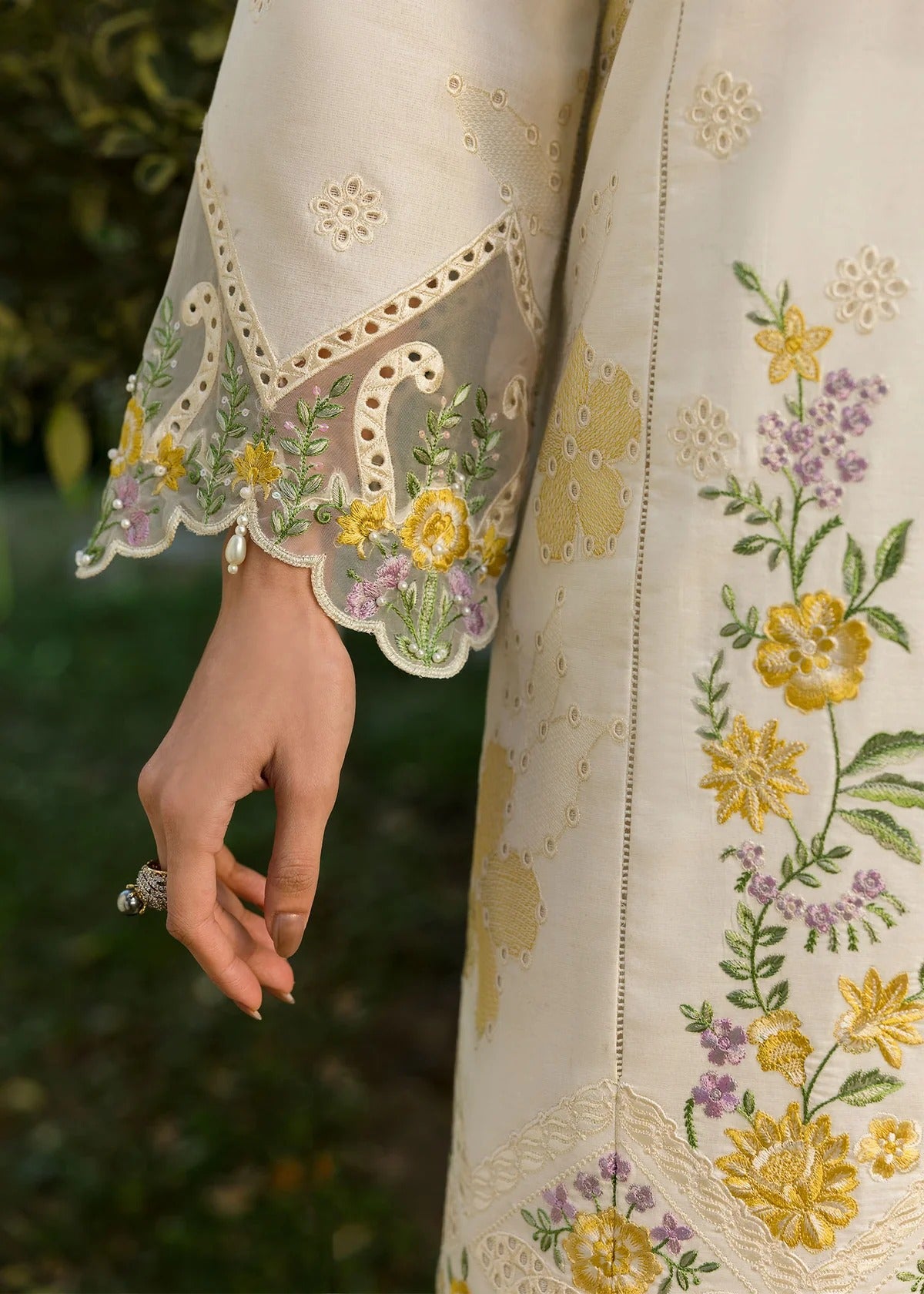Look elegant in this ivory embroidered lawn suit with chikan-kari panels, hand-work neckline, woven net dupatta, and cotton trouser for a timeless style.