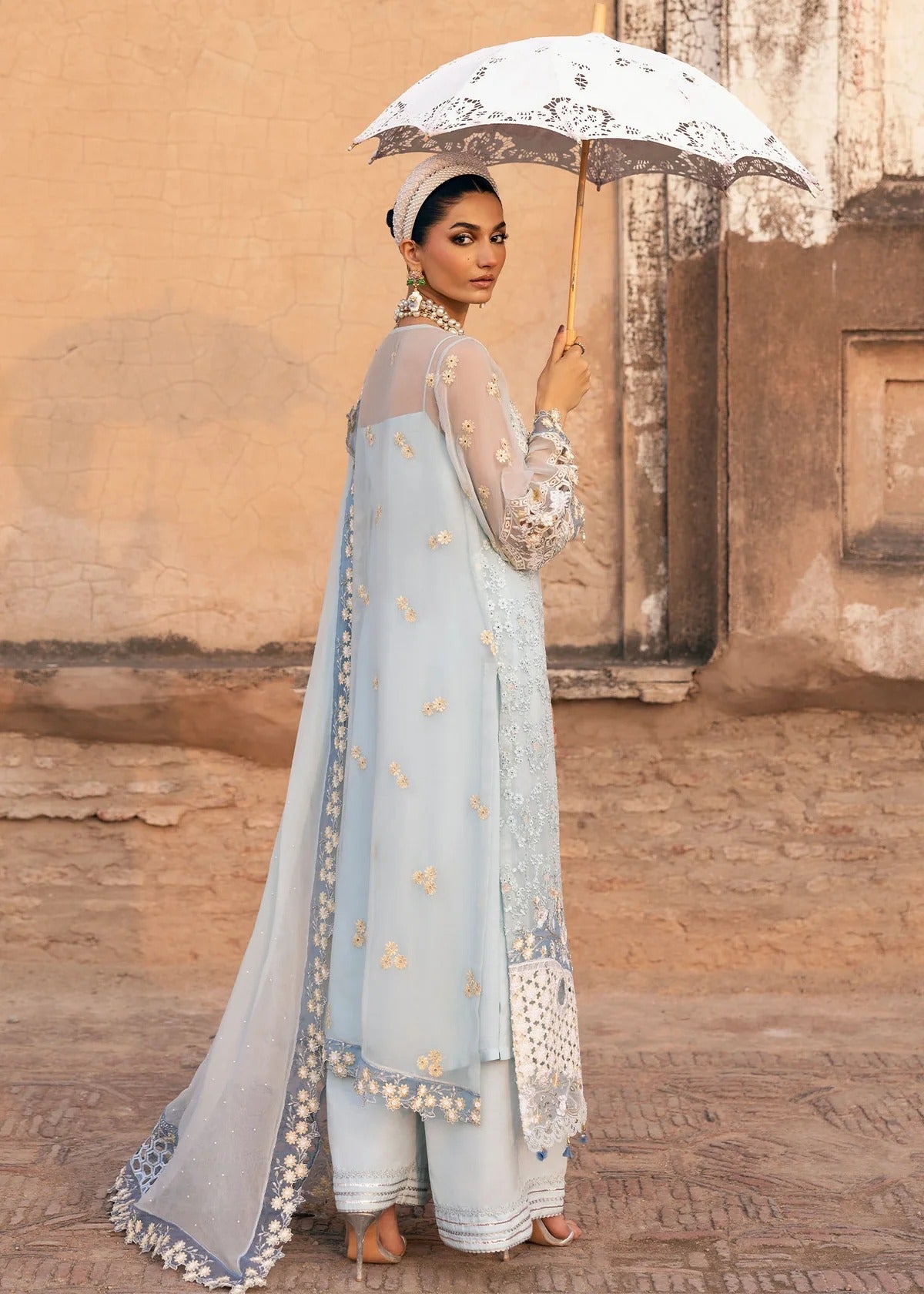 Luxury chiffon suit with hand-embellished neckline, 3D floral sleeve motifs, cutwork borders, diamante dupatta, and raw silk trouser — perfect for occasions.