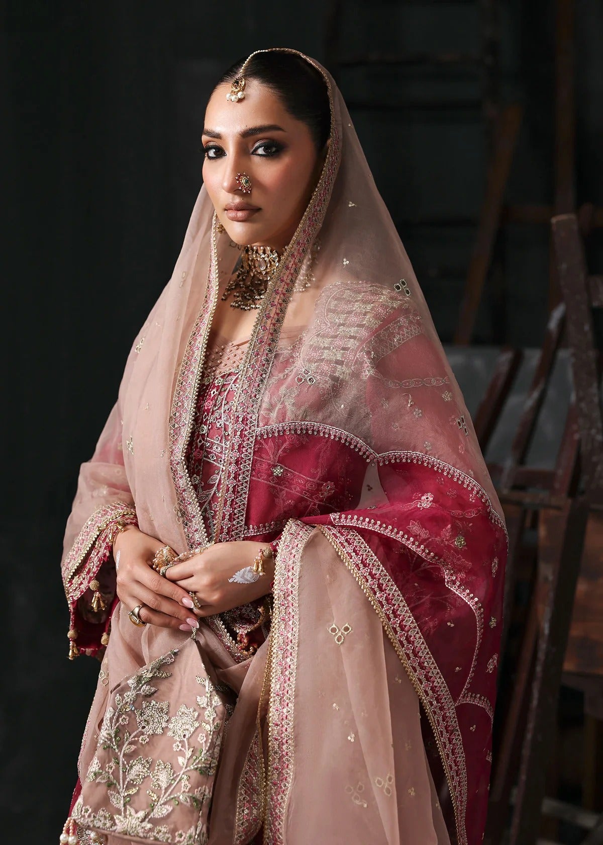 Chic rose pink organza suit with applique panels, cutwork neckline, embroidered dupatta, raw silk trouser, and elegant borders for a timeless festive look.