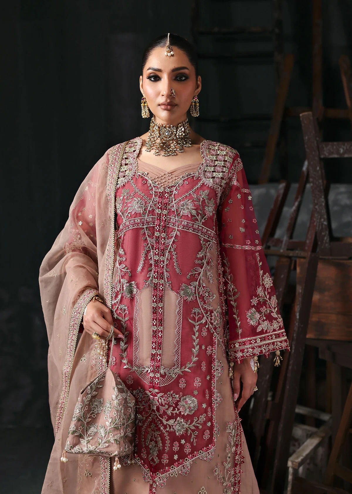 Chic rose pink organza suit with applique panels, cutwork neckline, embroidered dupatta, raw silk trouser, and elegant borders for a timeless festive look.