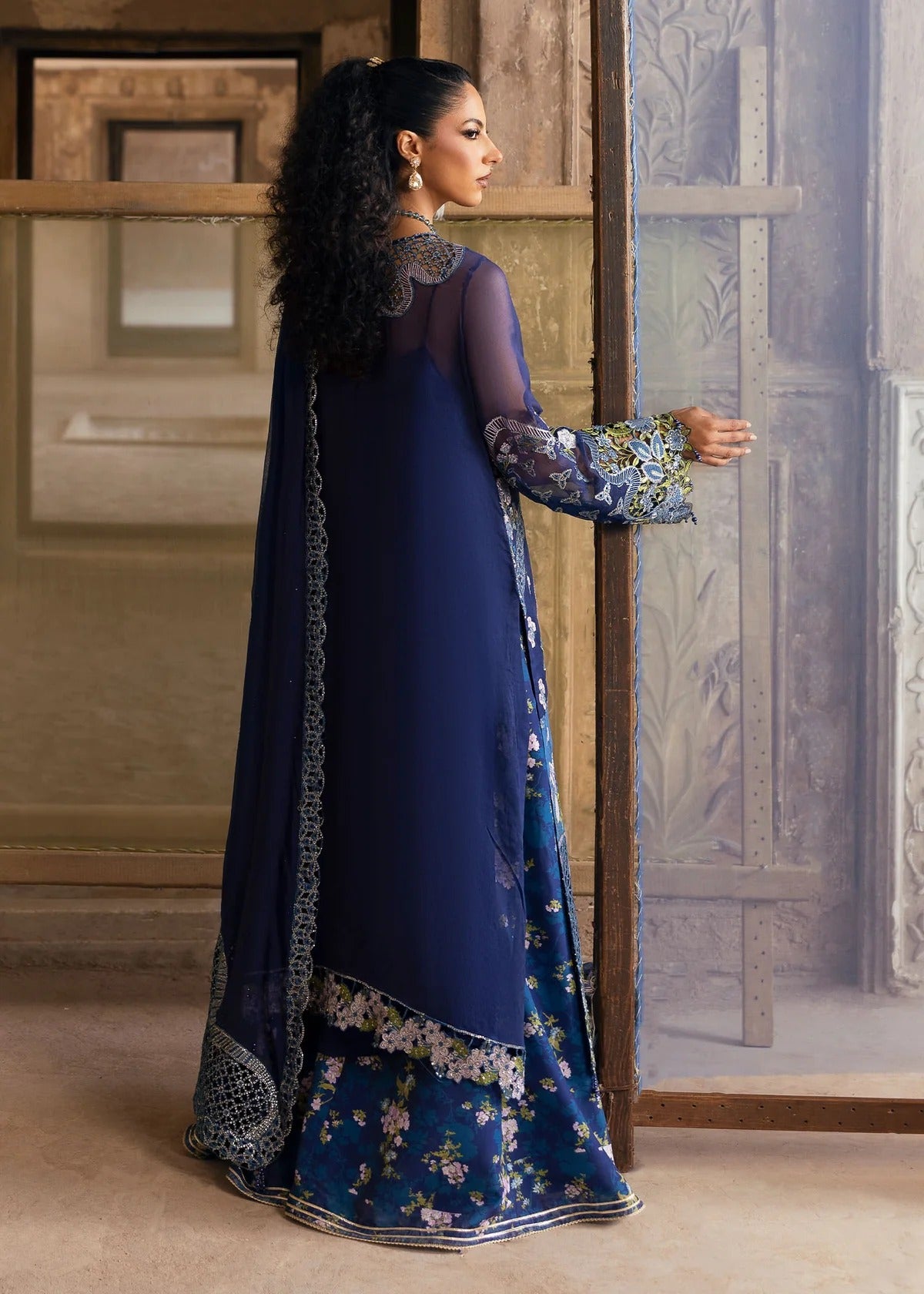 Stunning chiffon embroidered suit with hand-embellished neckline, cutwork motifs, diamante dupatta, and printed raw silk trouser for festive elegance.