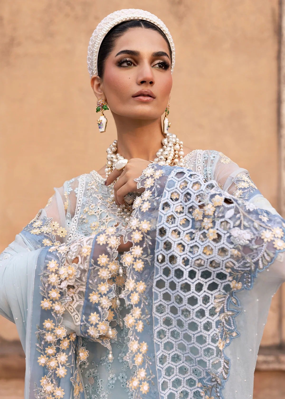 Luxury chiffon suit with hand-embellished neckline, 3D floral sleeve motifs, cutwork borders, diamante dupatta, and raw silk trouser — perfect for occasions.