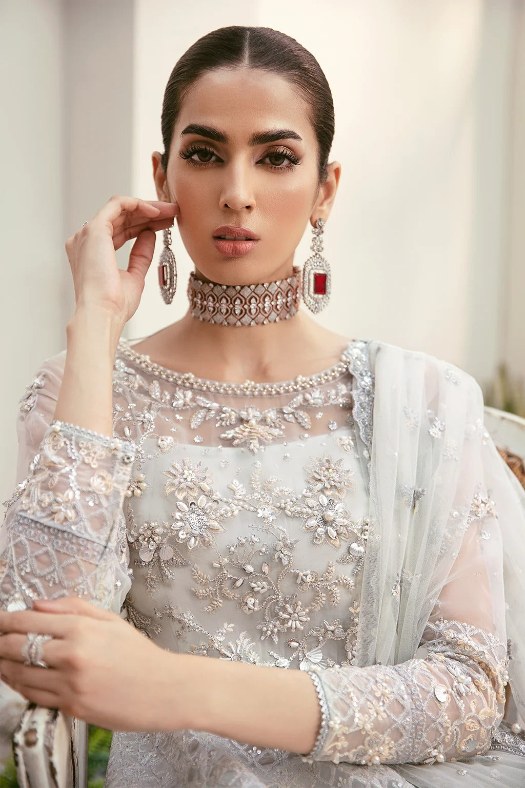 Elegant organza embroidered suit with hand-embellished bodice, cutwork panels, detailed borders, dupatta, and premium raw silk trouser fabric.