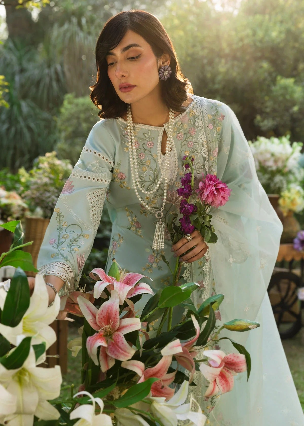 Elevate your style with this sky blue embroidered lawn suit featuring hand-work neckline, chikan-kari sleeves, net dupatta, and cotton trouser.