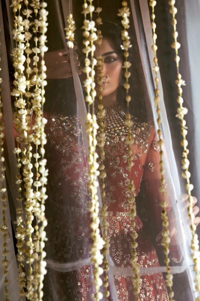 Elegant net dress with hand-embellished panels, blouse, sleeves & dupatta, paired with raw silk inner—crafted for refined beauty and timeless charm.