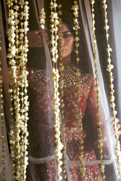 Elegant net dress with hand-embellished panels, blouse, sleeves & dupatta, paired with raw silk inner—crafted for refined beauty and timeless charm.