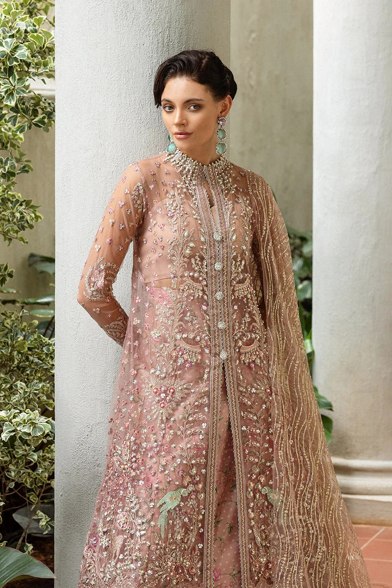 Elegant coral pink lehenga with embroidered net shirt, sequined dupatta, hand embellishments, and handmade tassels for a luxurious festive look.