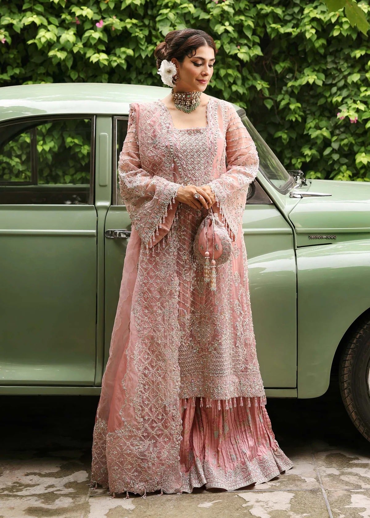 Ethereal blush rose suit with hand-embellished organza panels, ornate borders, and embroidered dupatta. A timeless choice for festive elegance.