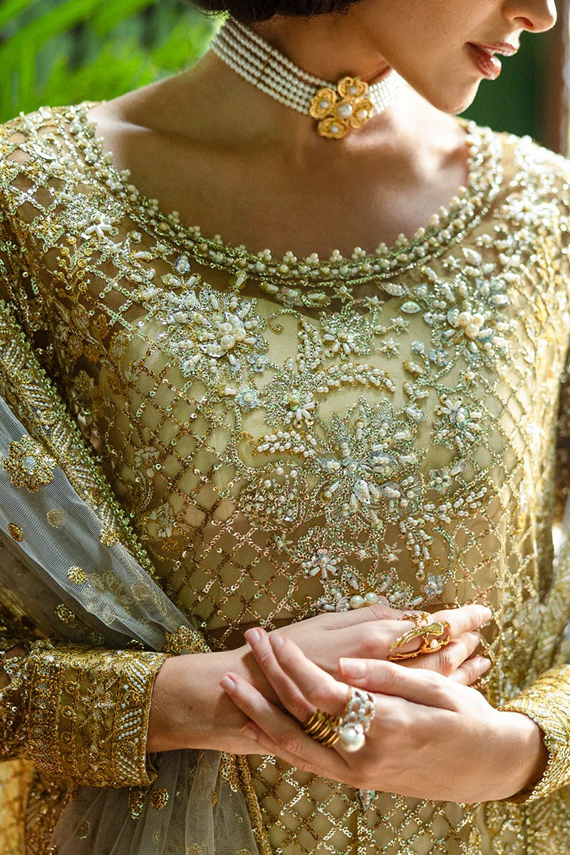 Elegant white & gold dress with embroidered net shirt, sequined dupatta, raw silk trouser, jamawar finishing, and hand-embellished neckline.