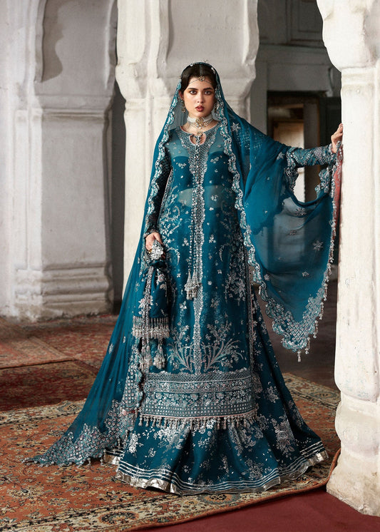 Graceful teal organza shirt with fine embroidery, silk sharara, and chiffon dupatta. Unstitched festive outfit perfect for elegant traditional occasions.