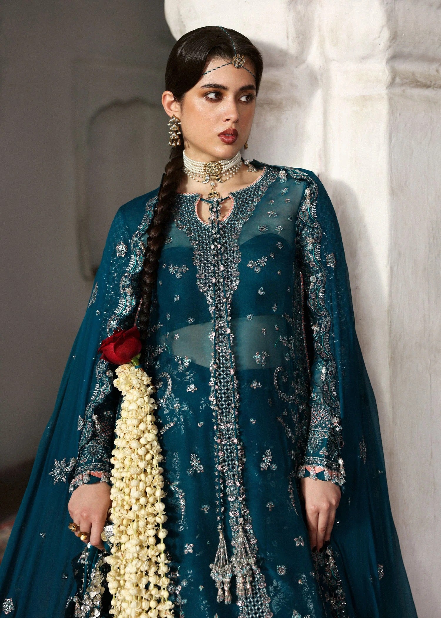 Graceful teal organza shirt with fine embroidery, silk sharara, and chiffon dupatta. Unstitched festive outfit perfect for elegant traditional occasions.