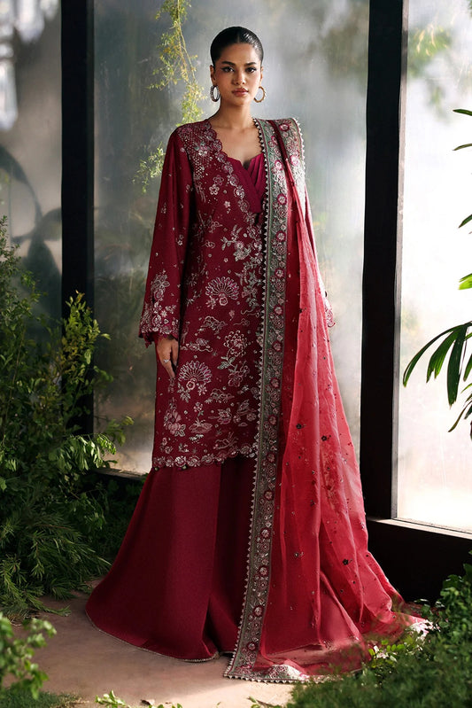 Striking cherry raw silk suit with embroidered panels, green organza dupatta border, and matching trouser for a bold festive look.
