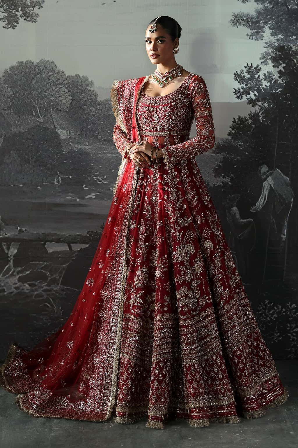 Luxurious net suit with hand-embellished panels, embroidered dupatta with motifs, and raw silk trouser — perfect for weddings and festive wear.