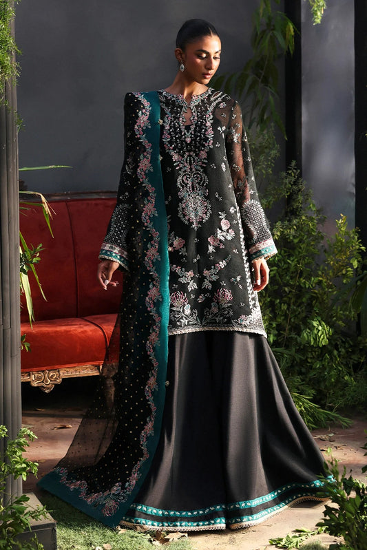 Stunning black khaadi net suit with embroidered panels, green & pink borders, block-printed organza dupatta, and raw silk trouser.