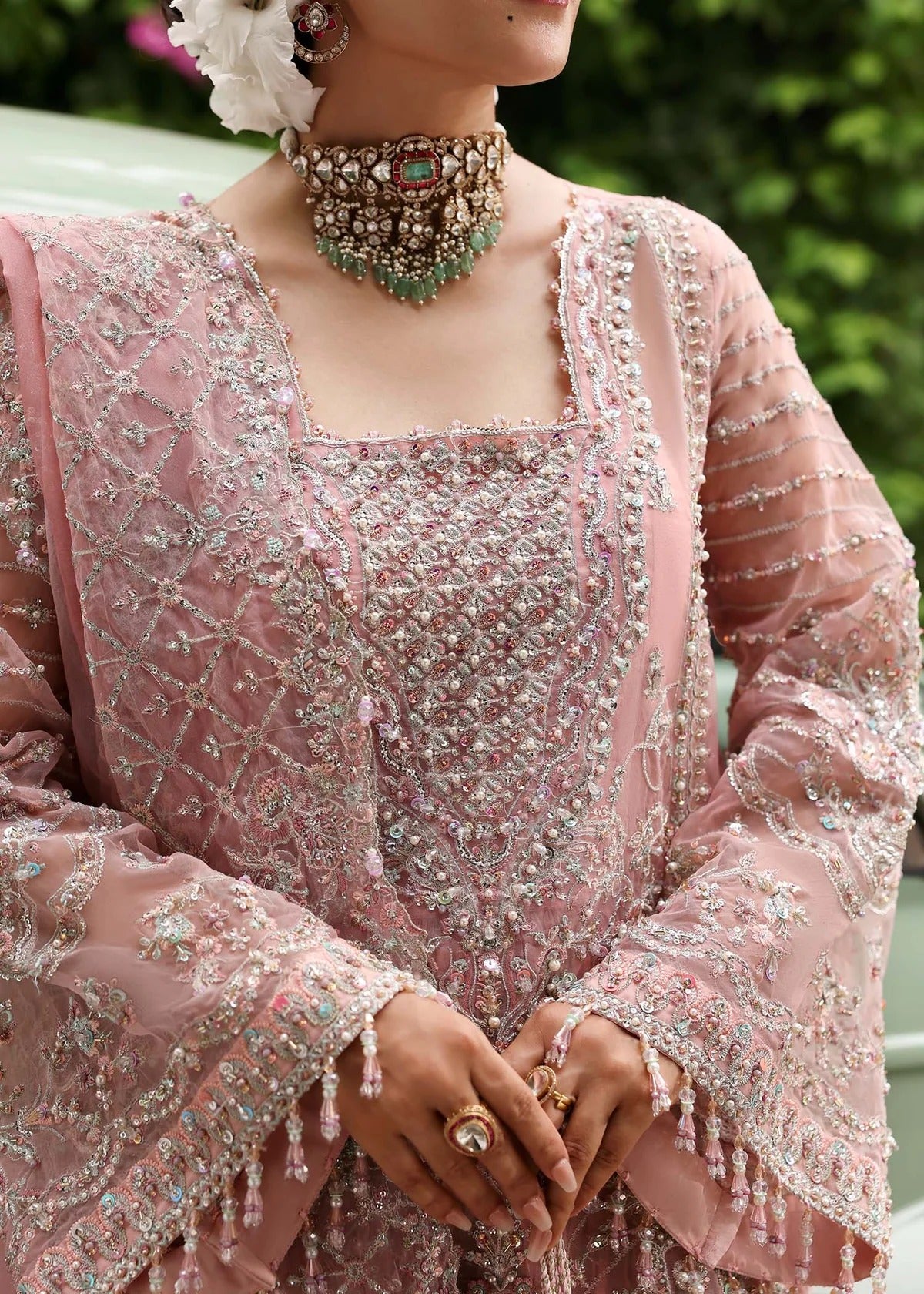 Ethereal blush rose suit with hand-embellished organza panels, ornate borders, and embroidered dupatta. A timeless choice for festive elegance.