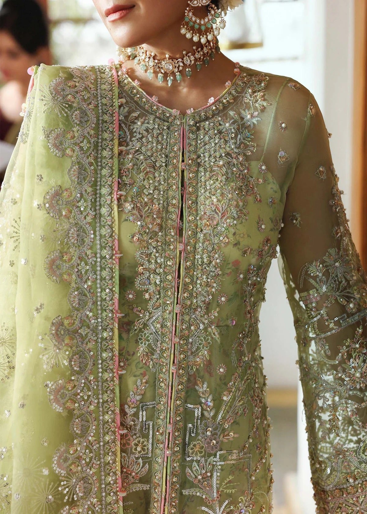 Vibrant parrot jade suit with hand-embellished organza panels, embroidered dupatta, and printed trouser—perfect for festive elegance.