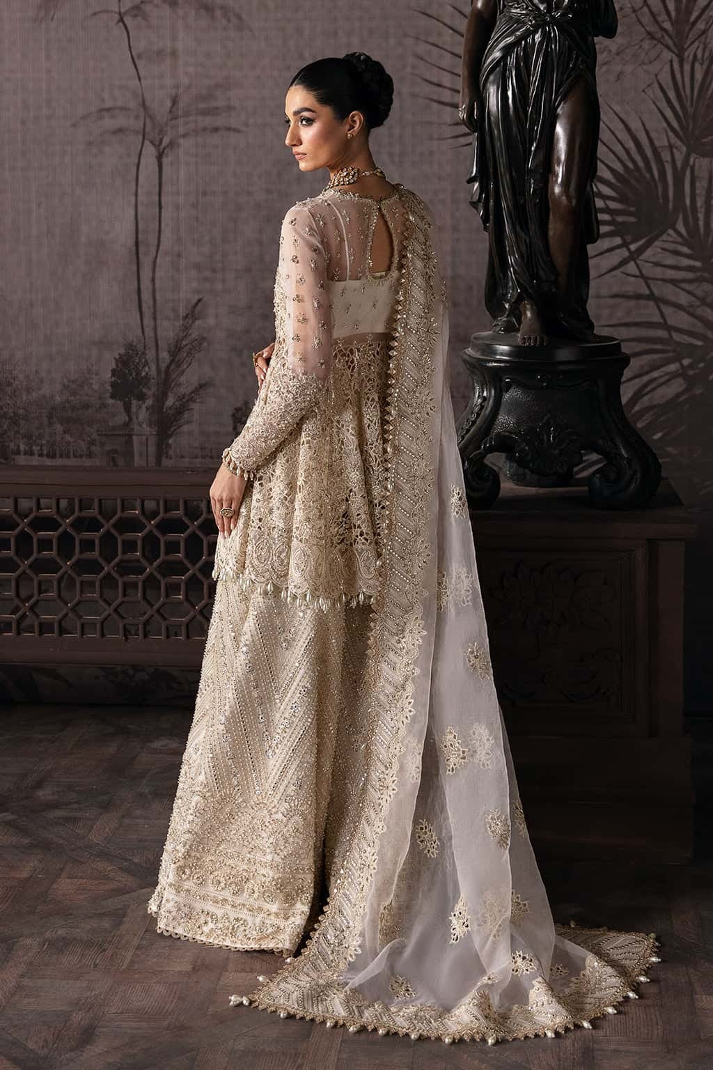 Luxurious organza suit featuring hand-embellished panels, embroidered dupatta, and raw silk trouser — perfect for festive and formal occasions.