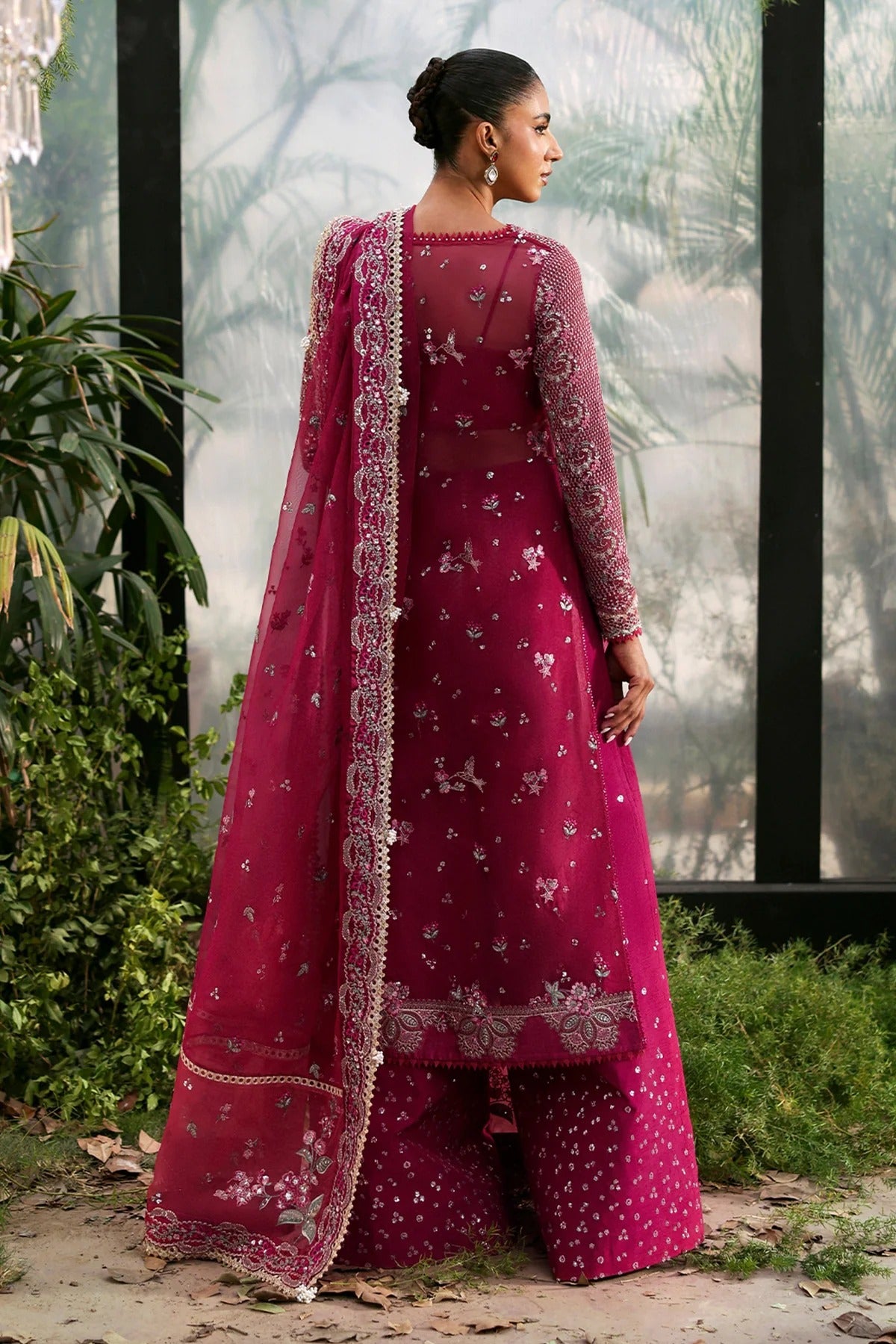 Elegant soft pink organza suit with embroidered panels, red accents, silk dupatta borders, and matching raw silk trouser for a refined look.