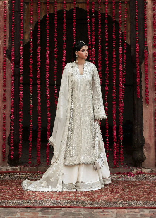Elegant ivory organza shirt with sequin embroidery, silk sharara, and chiffon dupatta. Unstitched luxury outfit exuding timeless grace and sophistication.
