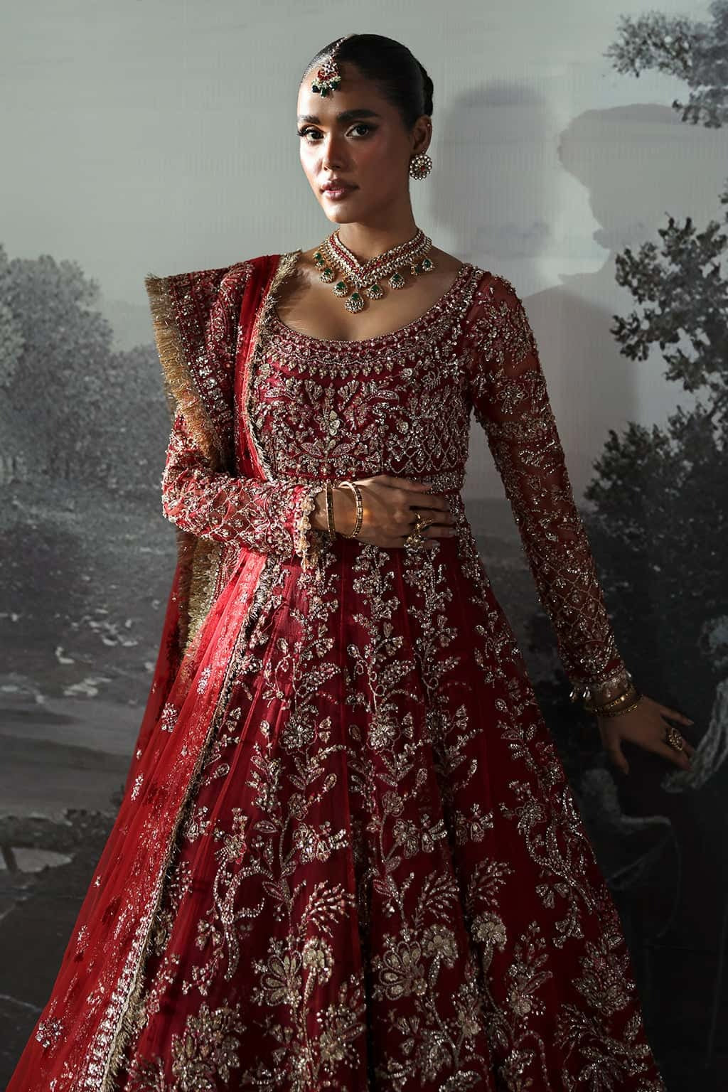 Luxurious net suit with hand-embellished panels, embroidered dupatta with motifs, and raw silk trouser — perfect for weddings and festive wear.