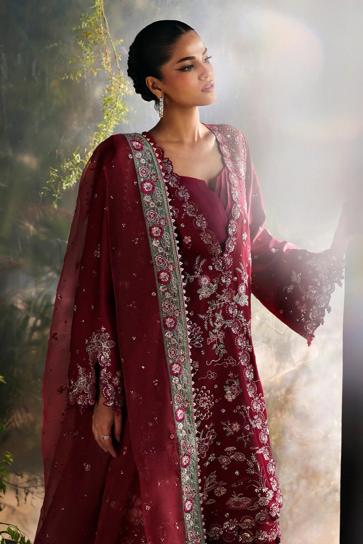 Striking cherry raw silk suit with embroidered panels, green organza dupatta border, and matching trouser for a bold festive look.