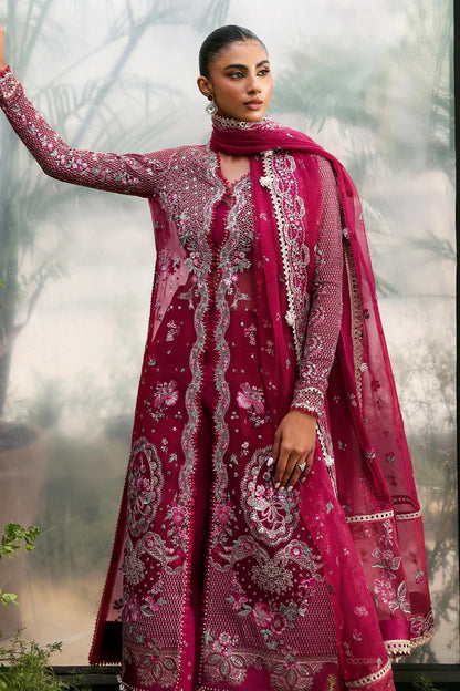 Elegant soft pink organza suit with embroidered panels, red accents, silk dupatta borders, and matching raw silk trouser for a refined look.