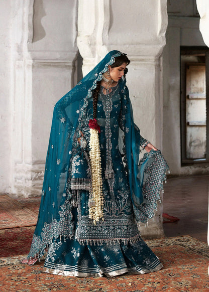 Graceful teal organza shirt with fine embroidery, silk sharara, and chiffon dupatta. Unstitched festive outfit perfect for elegant traditional occasions.