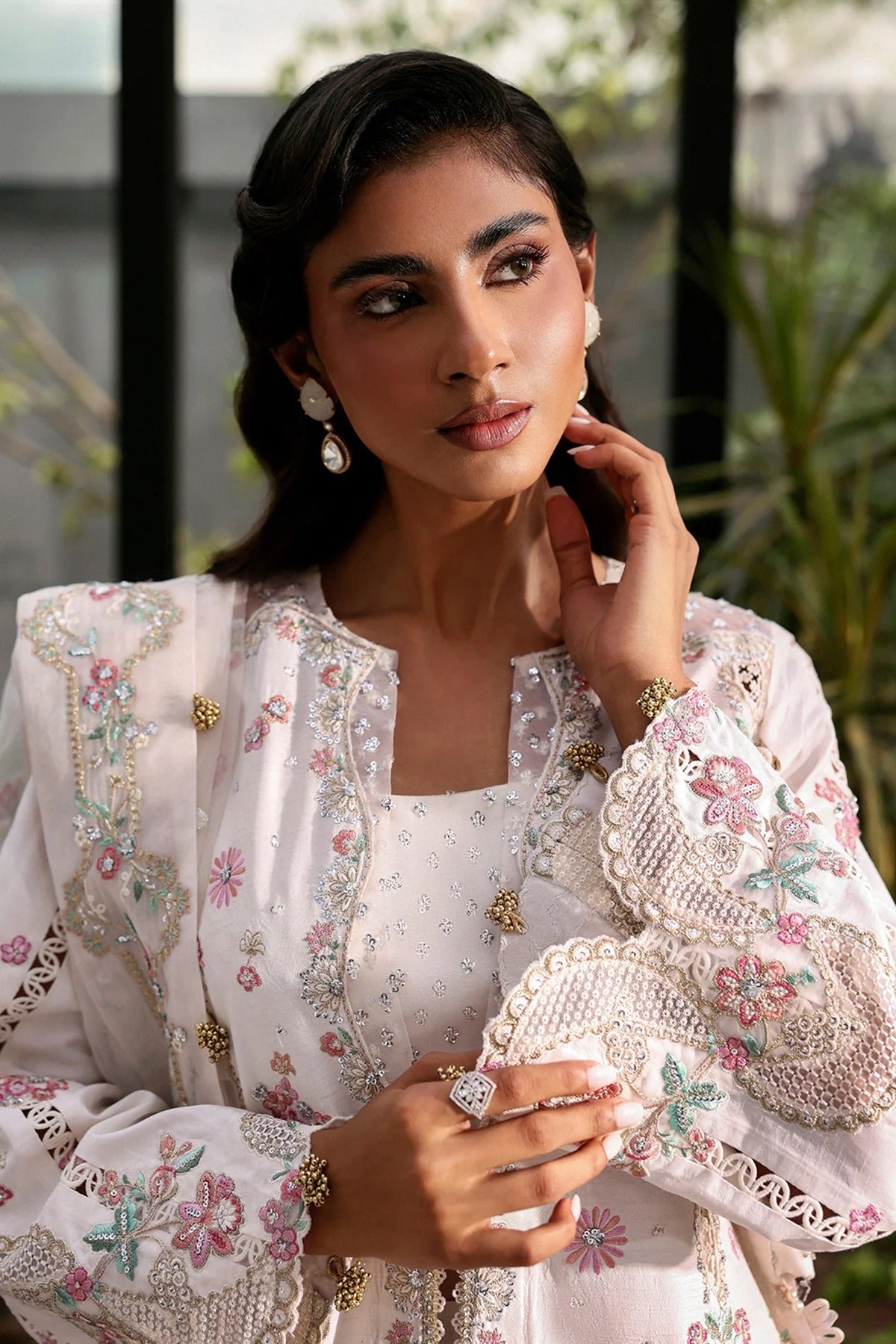 Elegant white raw silk suit featuring embroidered panels, organza borders, & a delicately embroidered dupatta with pallu  perfect for timeless festive elegance.