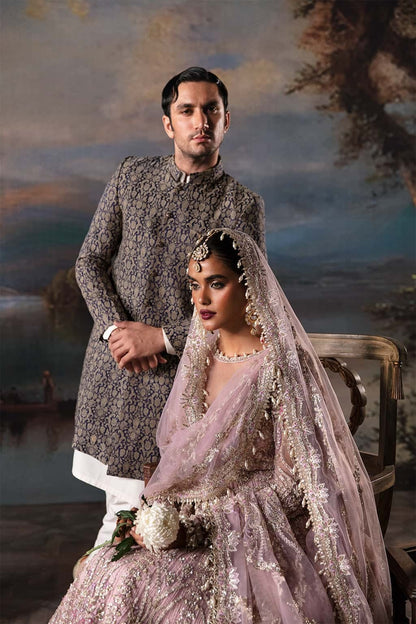 Luxurious net suit with embroidered panels, embellished sleeves, organza dupatta motifs, and raw silk trouser — a perfect festive ensemble.