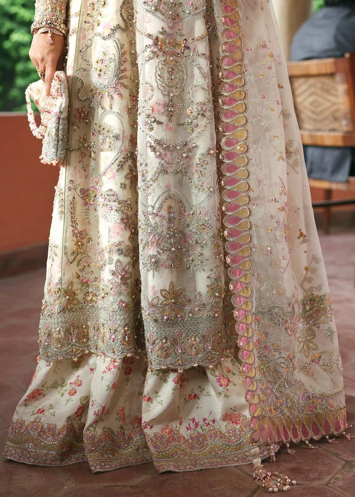 Ethereal ivory frost suit with hand-embellished organza panels, ornate borders, embroidered dupatta, and printed trouser for timeless elegance.
