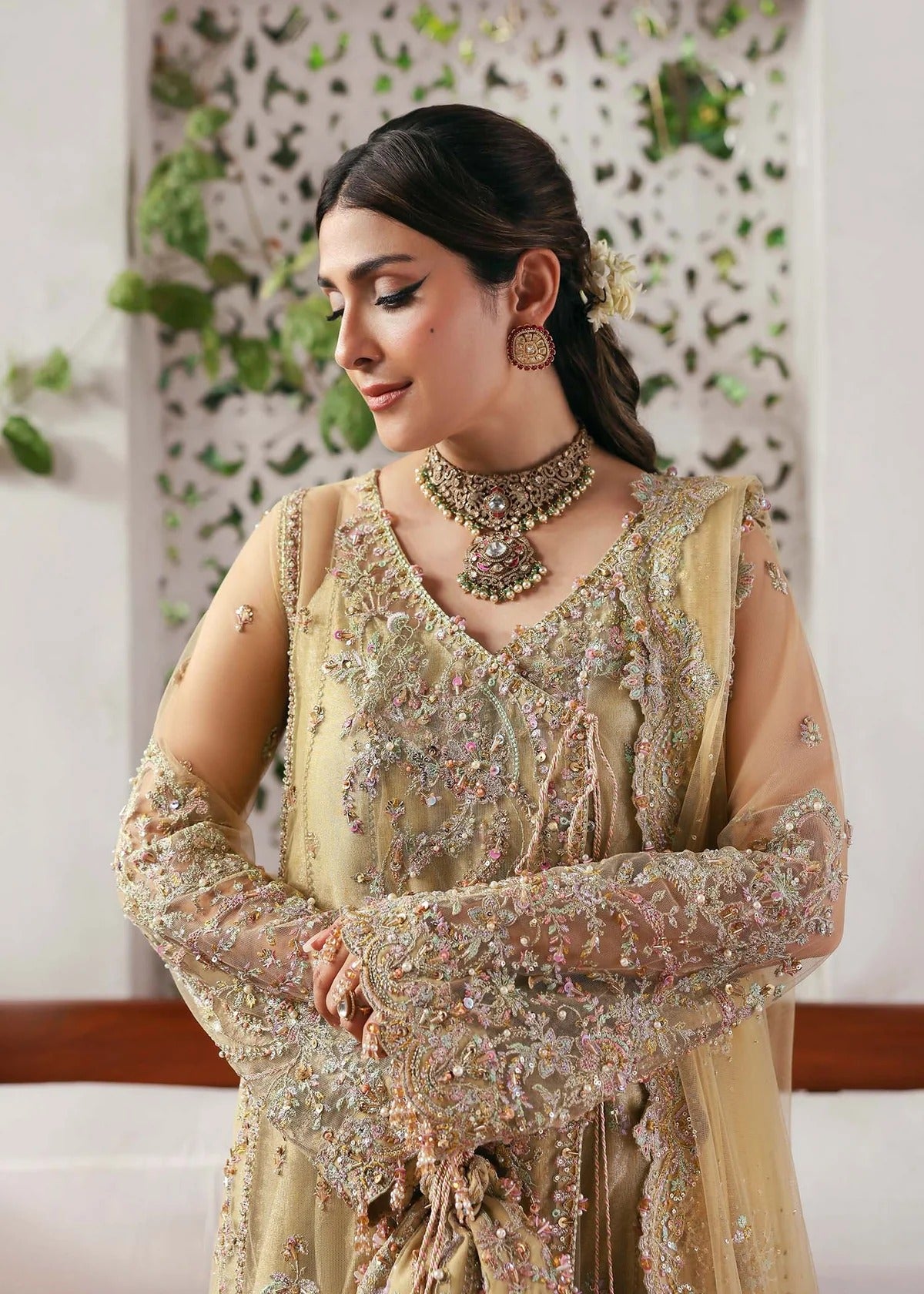 Elegant champagne beige suit with hand-embellished net panels, ornate borders, embroidered dupatta, and trouser for timeless festive sophistication.