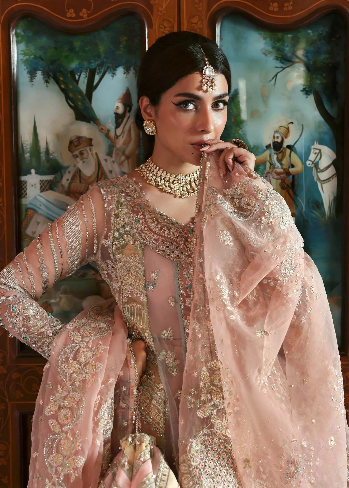 Stunning jewel-toned lehenga suit with hand-embellished shirt, embroidered borders, and organza dupatta for a regal festive look.