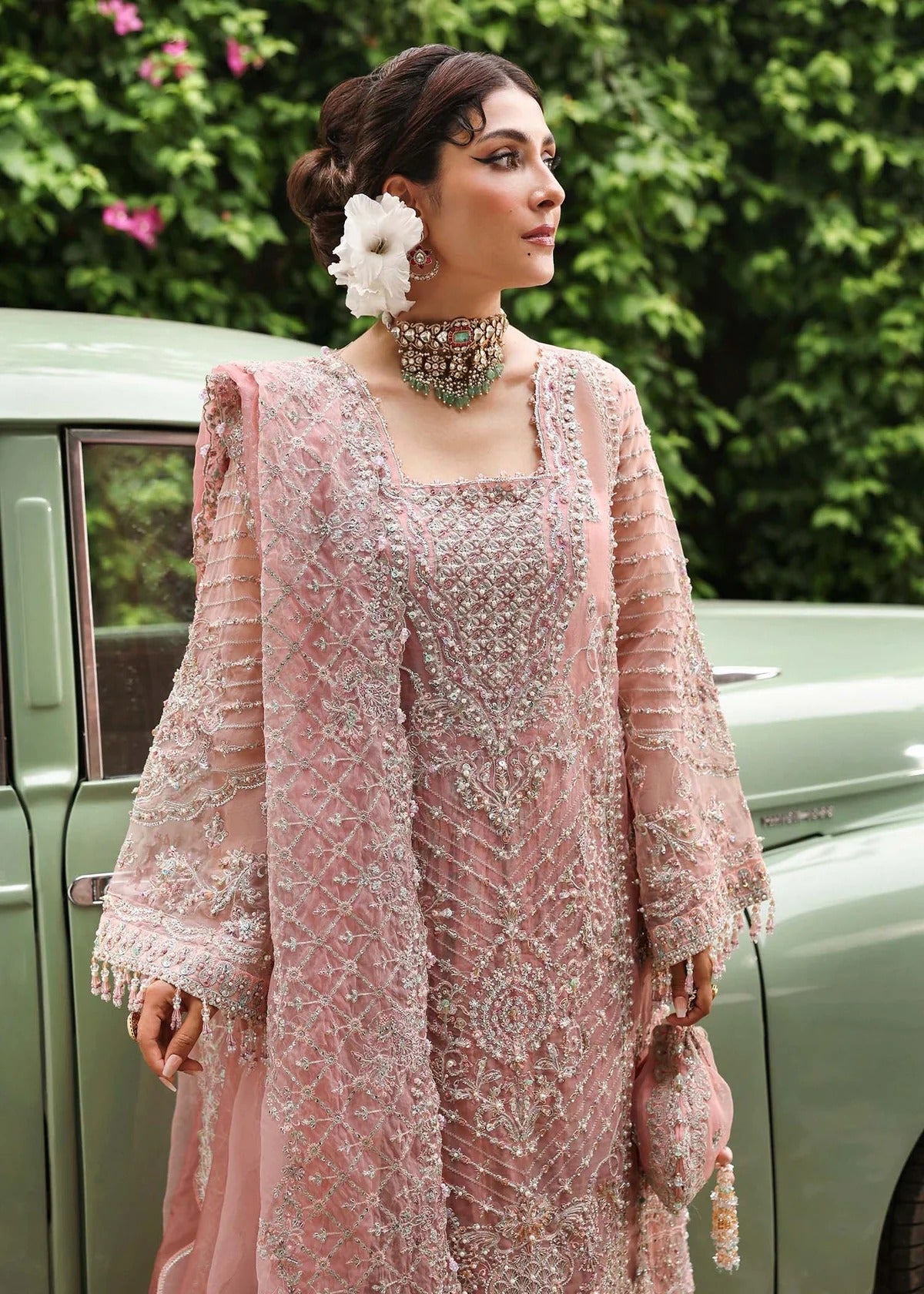 Ethereal blush rose suit with hand-embellished organza panels, ornate borders, and embroidered dupatta. A timeless choice for festive elegance.