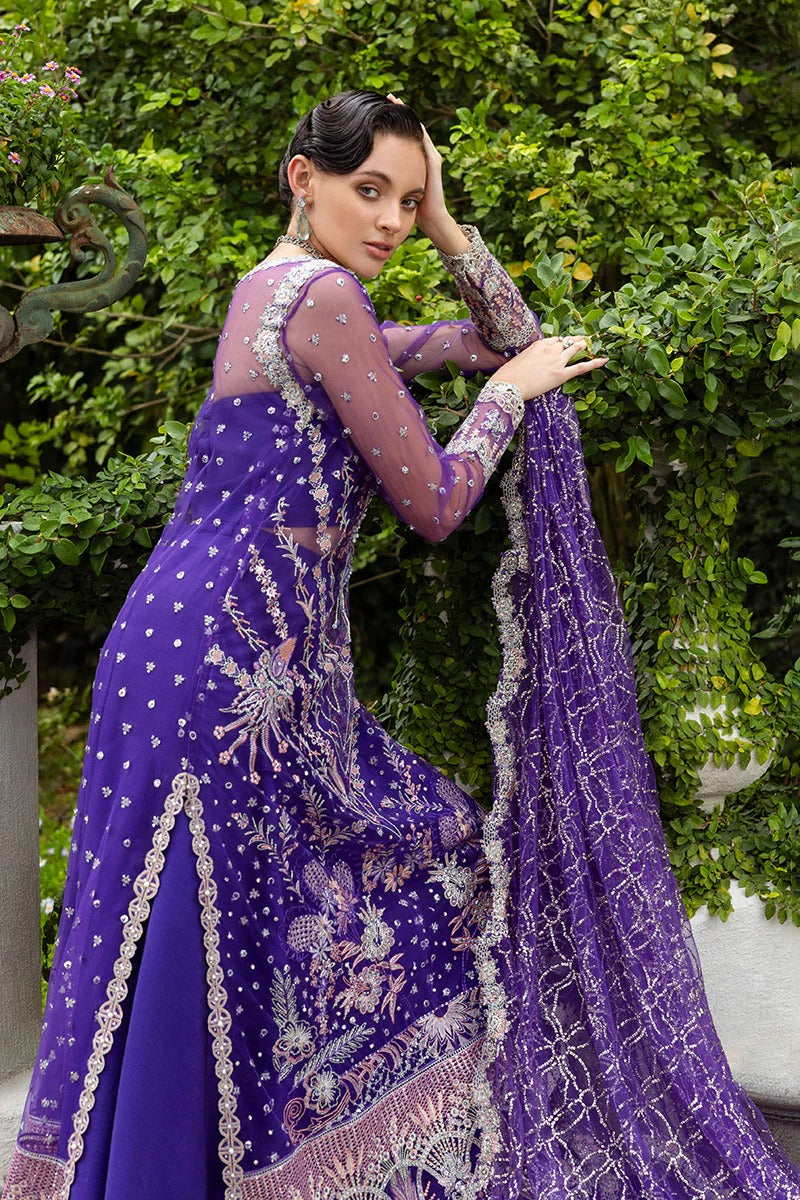 Luxurious purple dress featuring embroidered net shirt, sequined dupatta, raw silk trouser, pearl embellishments, and handmade tassels.